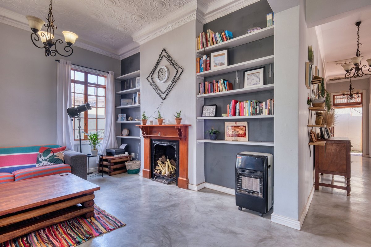 White built-in shelves with books and pictures on both sides of a wood fireplace mantel