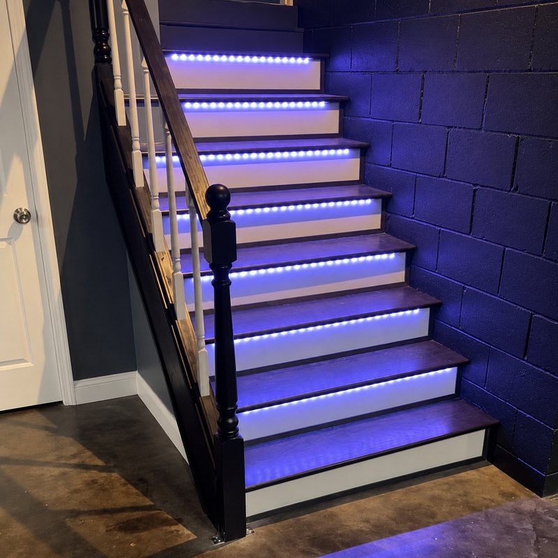 Basement staircase with dark-stained treads, white risers, and white balusters