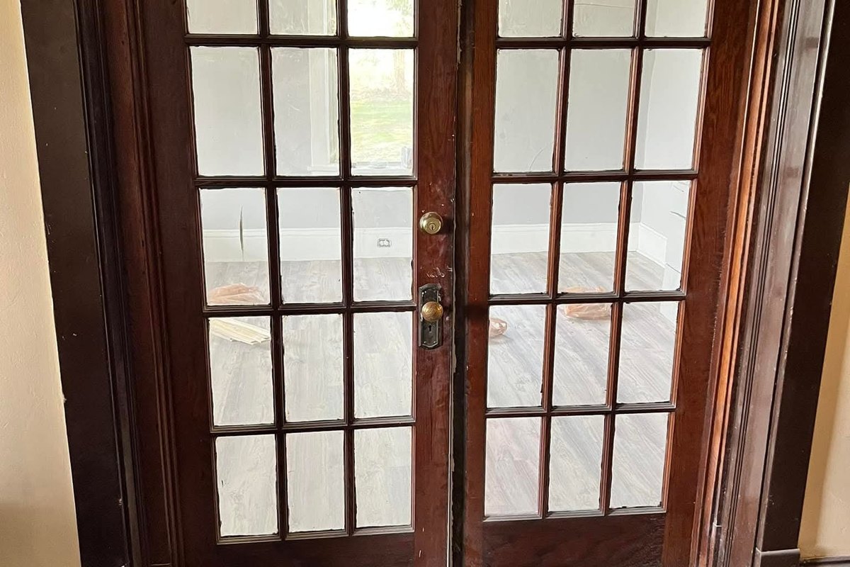 Pair of dark wood French doors with glass panes in a dark wood frame