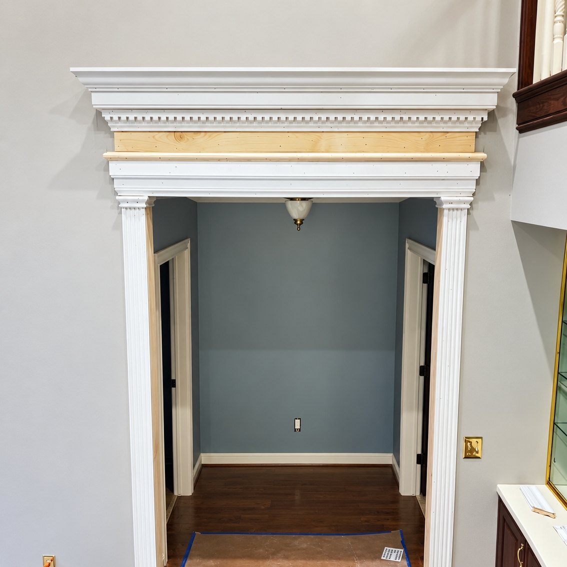 Cased opening with fluted white pilasters and a built-up dentil header
