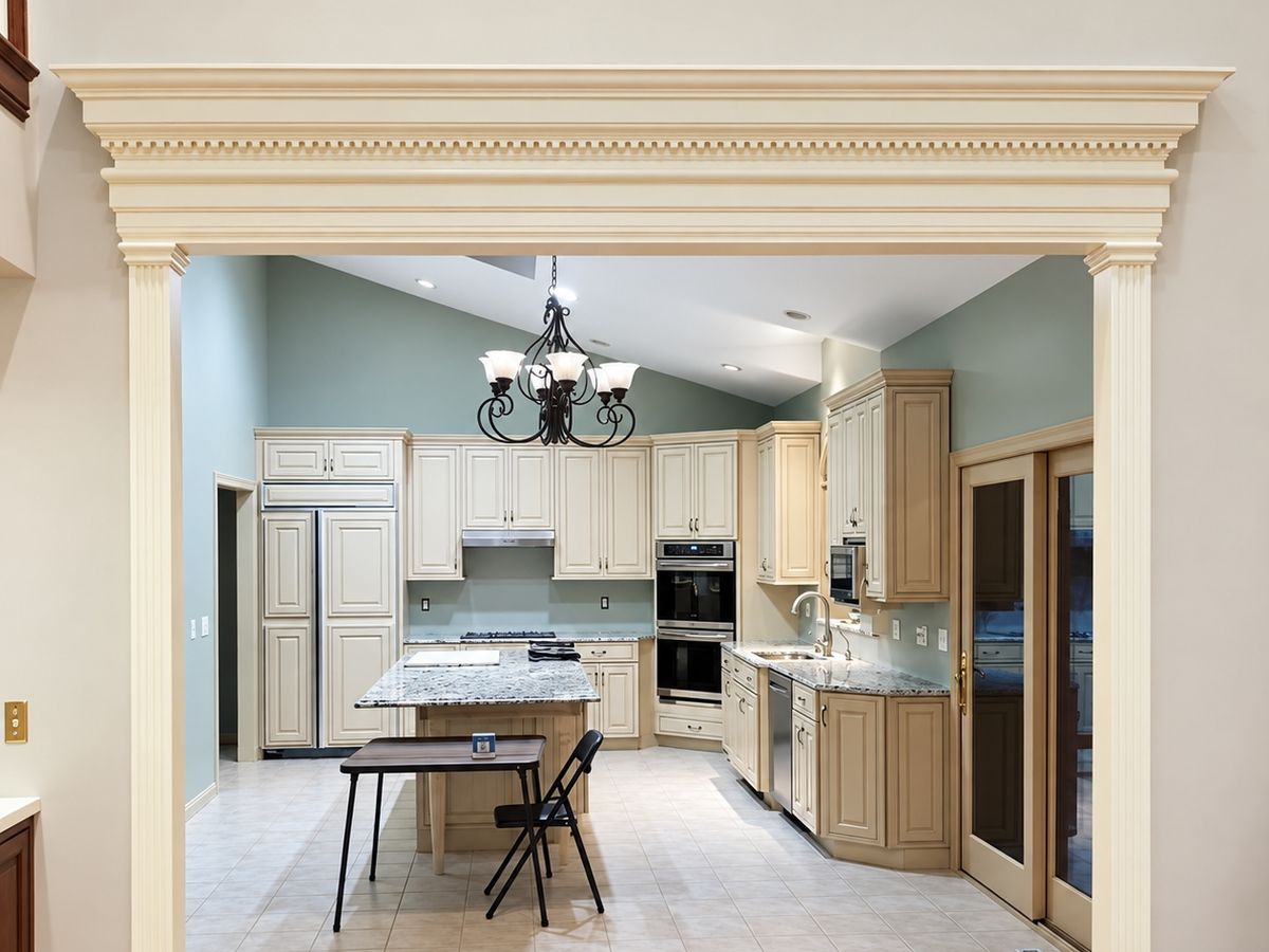 Finished wide cased opening painted cream with fluted pilasters and a dentil cornice header