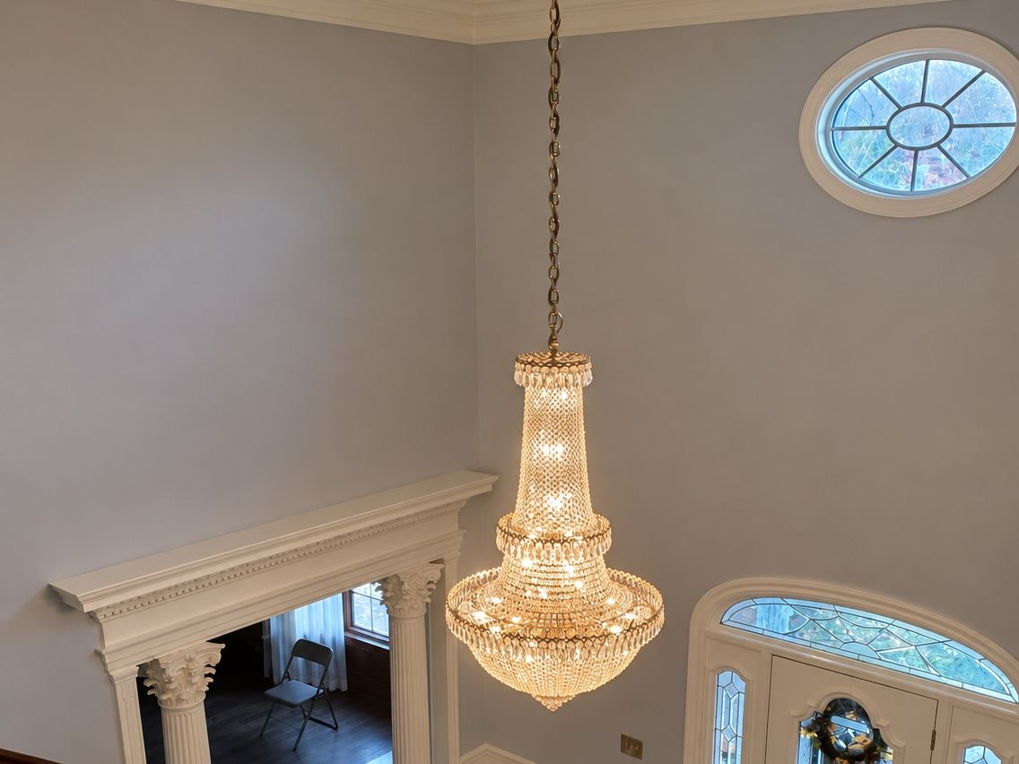 Looking down into a two-story foyer: a large crystal chandelier