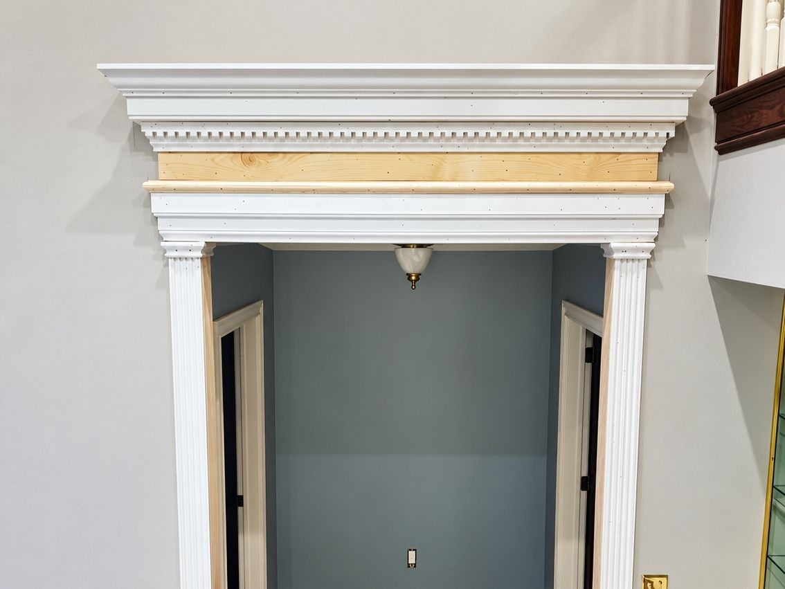 Cased opening with fluted white pilasters and a built-up dentil header