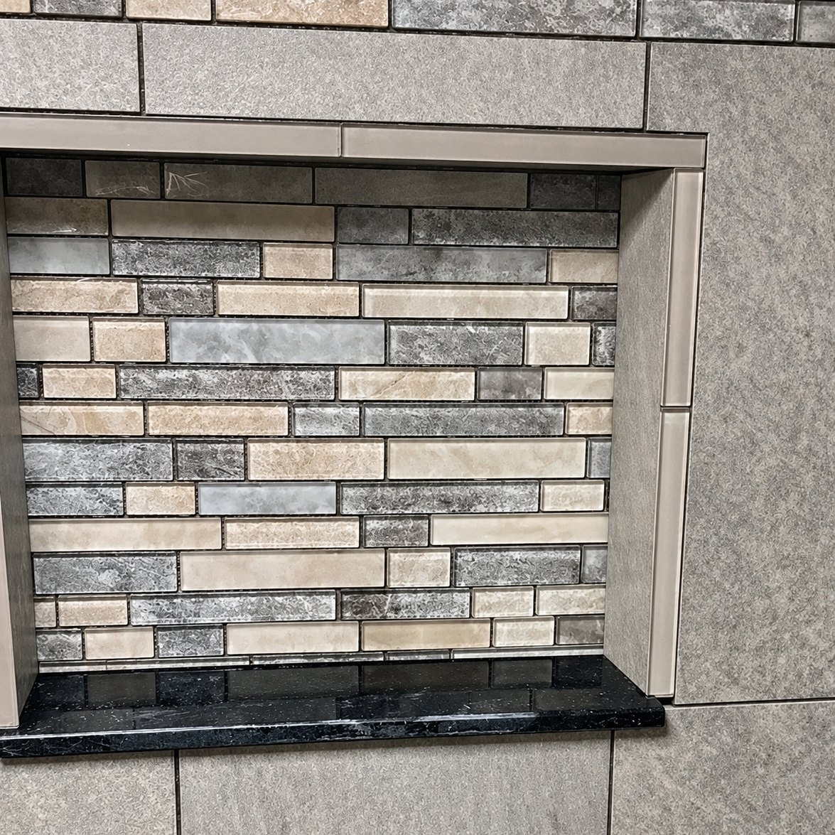 Tiled shower niche with a mosaic of glass and stone tile